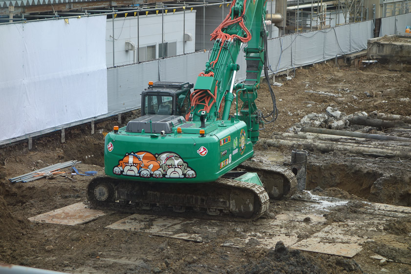 An excavator outside Akita station decorated with bulldogs.