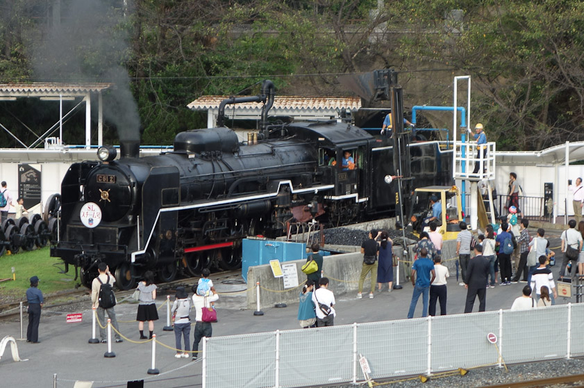 Engine C612 being refilled with water from the blue pipe and with coal from the yellow front loader before it enters the turntable. This was the second engine of Class 61, bilt 1948. This class was the first in Japan to incorporate automatic stokers.