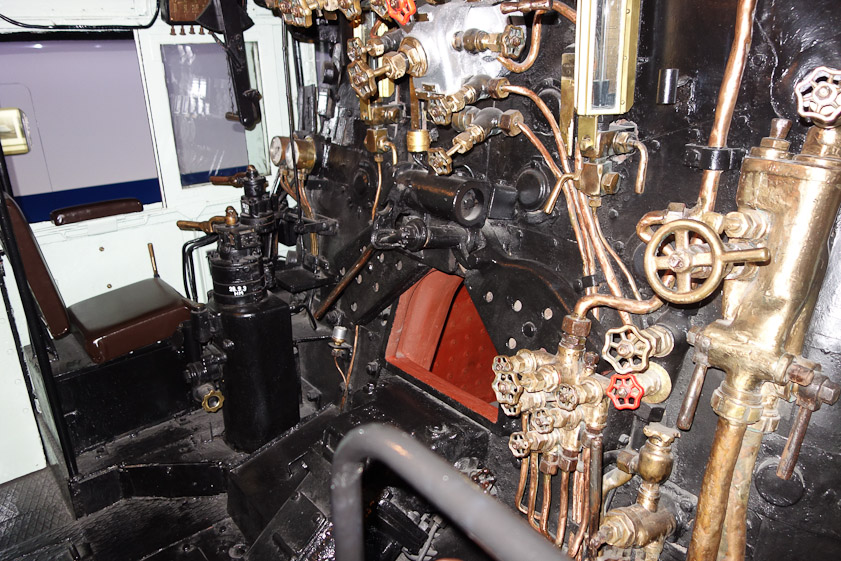 Engine cab of C6217. The doors (black with holes) are open) to the firebox (red). That is presumably the engine driver's seat on the left.