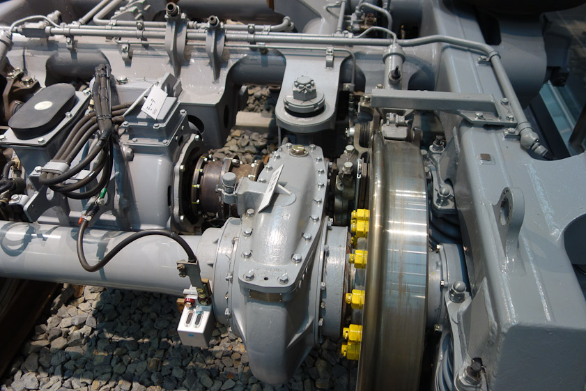 The shinkansen wheel (shiny silver at right) is driven via a transmission (blue unit to the left of the yellow nuts) by an electric motor (unit under the bundle of black wires).