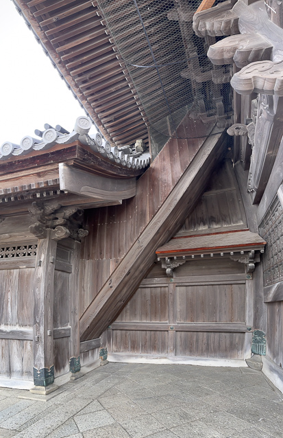 Curious, complicated woodwork at the side of the gate