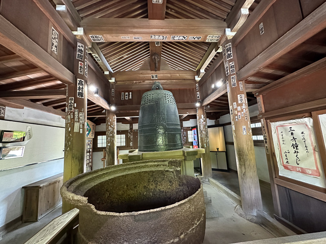 I think the object in the foreground is a broken cooking pot. I wish I knew what the many inscriptions on pieces of paper glued to the beams were about.