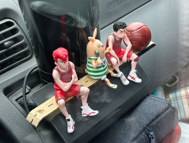 Figures on a car's dashboard parked oitside the Okinawa  Prefectural Museum