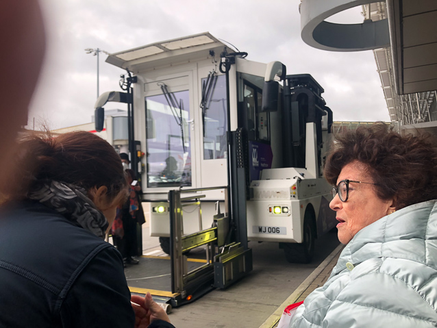 Since I and the lady on the right were traveling in wheelchairs at Heathrow we were carried to the plane in a special transporter with an elevator at the front. I was wheeled onto the platform where Mariana is standing and lifted to the passsenger compartment behind the glass door with the windshield wiper.