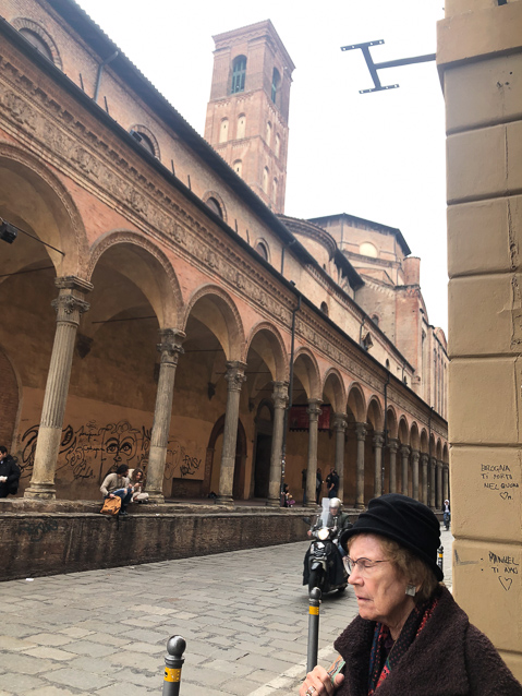 Mariana on Via Zamboni at the soith side of Piazza Giuseppe Verdi in the University quarter with one of the many towers of Bologna. This one is aprt of the Basilica de Giacomo Maggiore