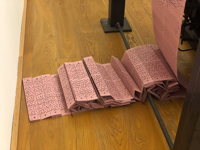 The puncched cards specifiy the warp threads to be raised for a single weft thread. That is, the card is read by a matrix of 8x50 (if my count is correct) pins that are connected to the headles that pull wapr threads up to form the shed through which the shuttle passes, draing a weft thread.