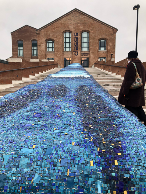 The entrance is on the 2nd floor, reached by a long stairway divided by a mosaic to blue tesserae.