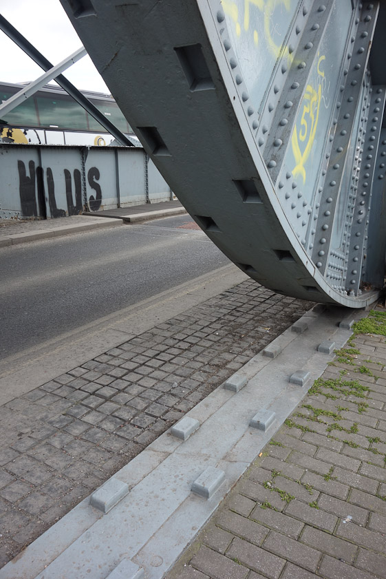 The double rack fixed to the pavement engages the square holes in the large wheel.