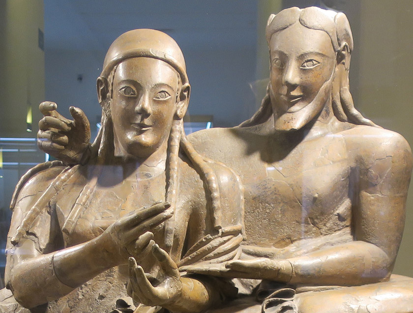 They were holding things in both hands. She has a scarf or cap over her head, while his hair is parted and uncovered.