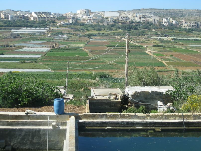 Most farms had a well such as we'd seen, from which water was pumped to a small open reservoir that fed irrigation pipes to the fields below by gravity.