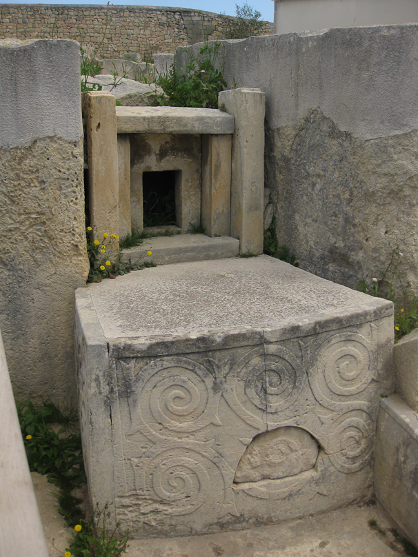 An altar at Tarxien Temples in which the excavator Temi Zammit in 1915 found a deposit of fourteen flint flakes, pieces of bone and pottery that had not been disturbed for three and a half millenia. These objects were behind the semicircular plug in the front of the altar. with the spiral decoration.