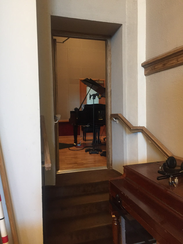 The pianist could see the orchestra through a thick glass door.