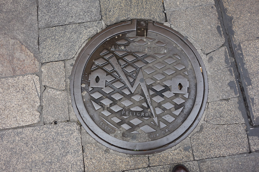Manhole cover in Salamanca. The words say high voltage, danger.