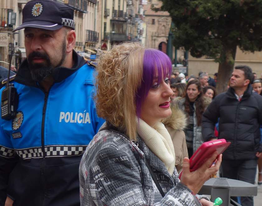 She may the mother of one of the kids, since the outfit of their confraternity is purple velvet.