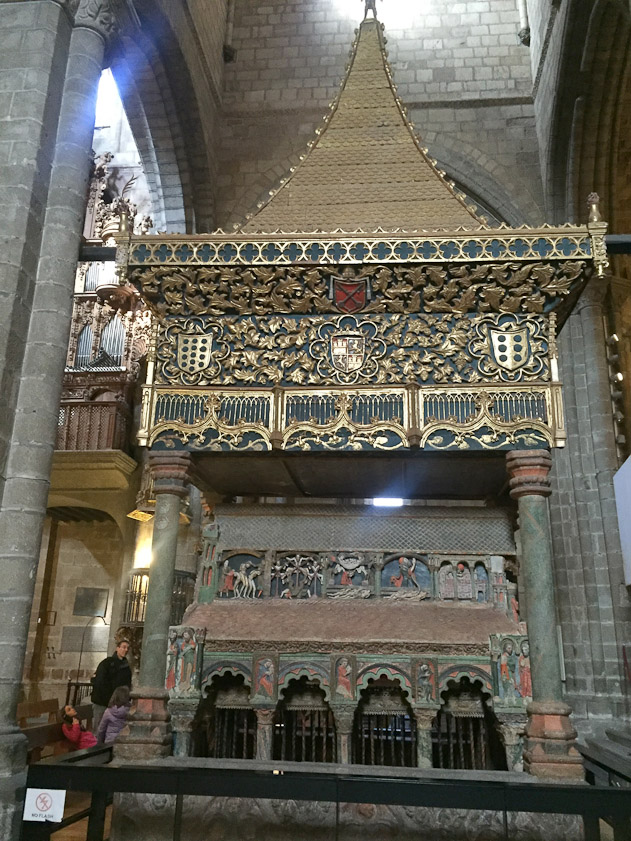 The gilded canopy was added in 1465. The five panels on the side of the sarcophagus show scenes from the martyrdom.
