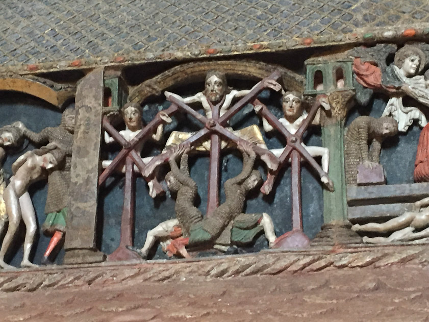 On the left, the clothes are stripped off the three martyrs and they are led off by their hair. In the second scene their bones are broken while attached to X-shaped machines being worked from below by two soldiers.