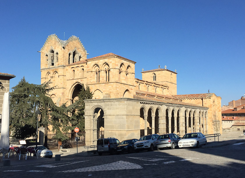 The portico on the southwest side (closest to the camera) appears to be much later than the Romanesque church.