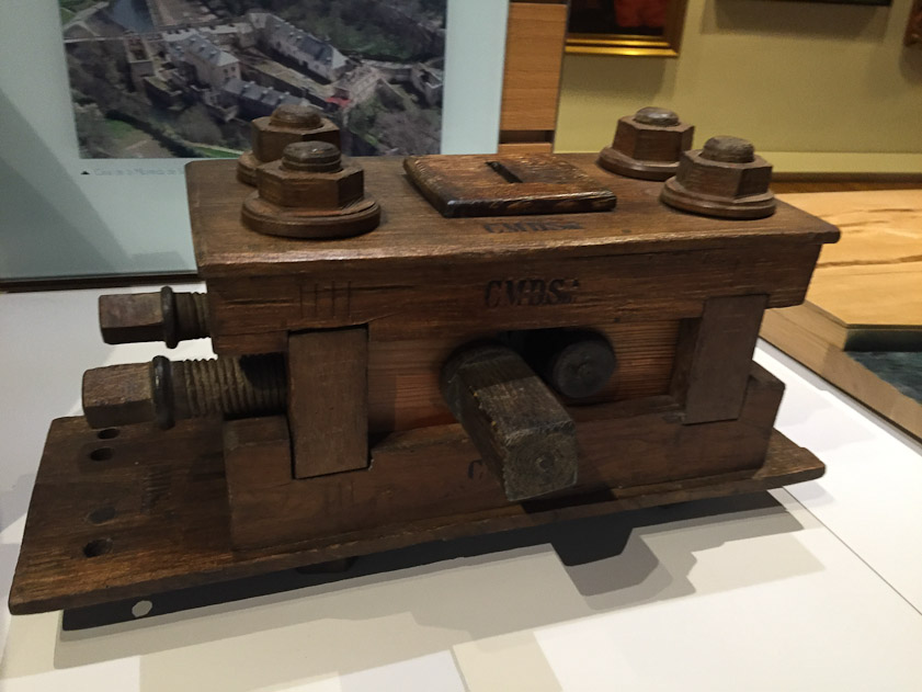 A 19c model of the minting/coining mill. The square shaft pointing at the camera was diven by one crown gear, while the round shaft to its right was driven by the other crown gear. The two screws on the left set the gap between the two mill shafts, through which the metal to be coined and laminated was fed.