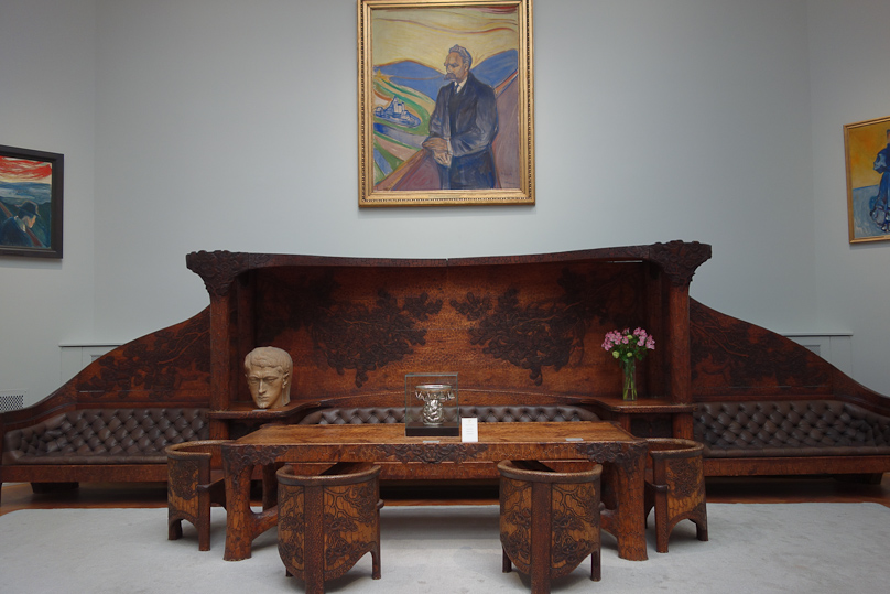 Large wooden set in a room full of Edvard Munch paintings.