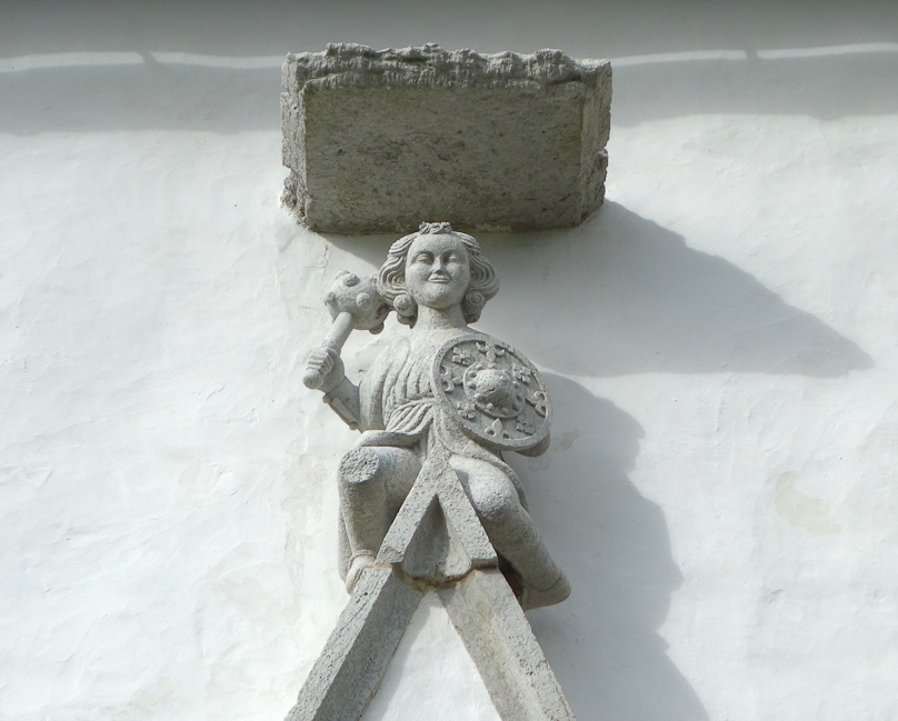 Armed guardian over the south doorway at Horsne church.