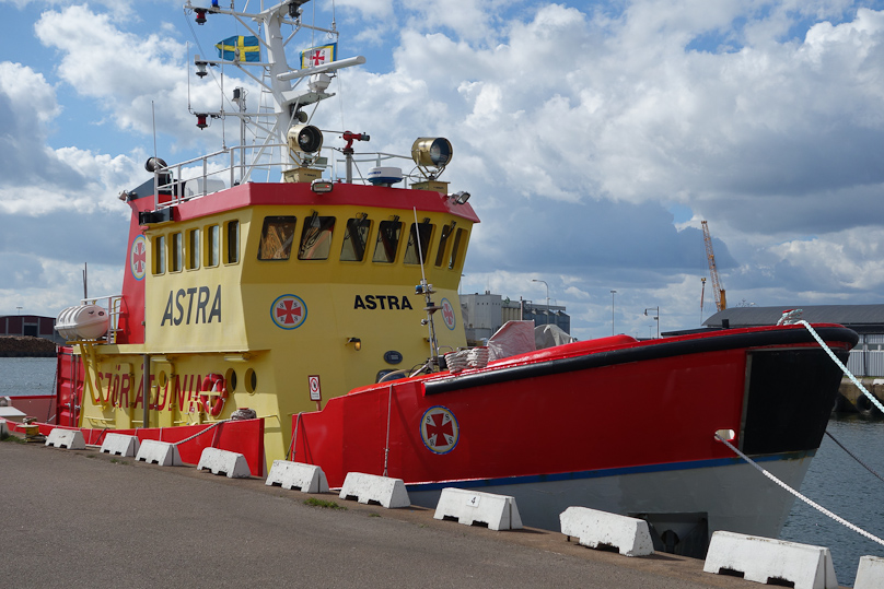Life saving boat docked in front of the preceding buildings.