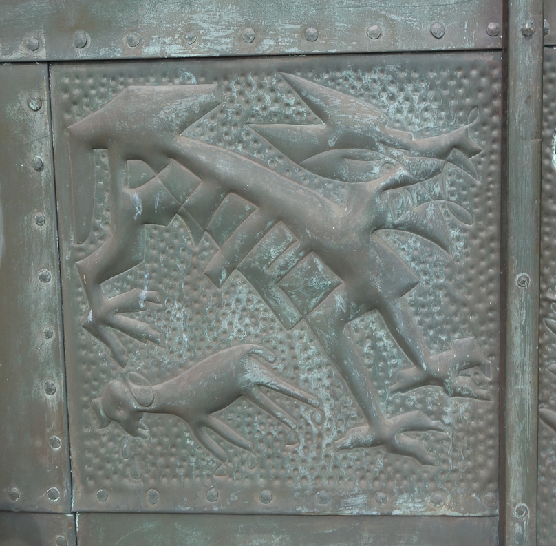 In the lower left panel is a figure with three visible legs with three-toed feet. Its tail hangs down in the upper left of the panel. its head is confused. Below this is a goat.