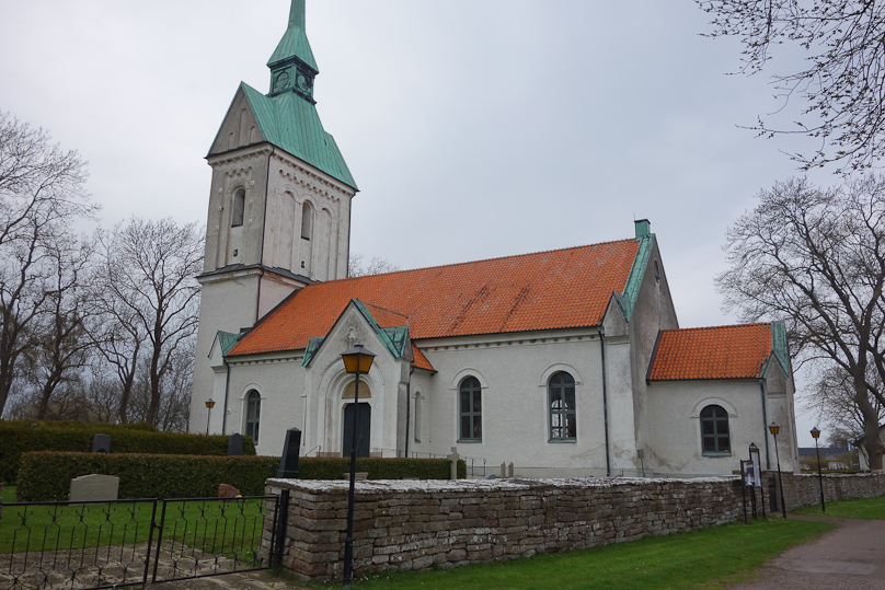 Gräsgårds church with odd tower that includes a small house with roof running north-south transverse to the roof of the nave. A team of Church lawn mowers removed a gravestone when we were there.