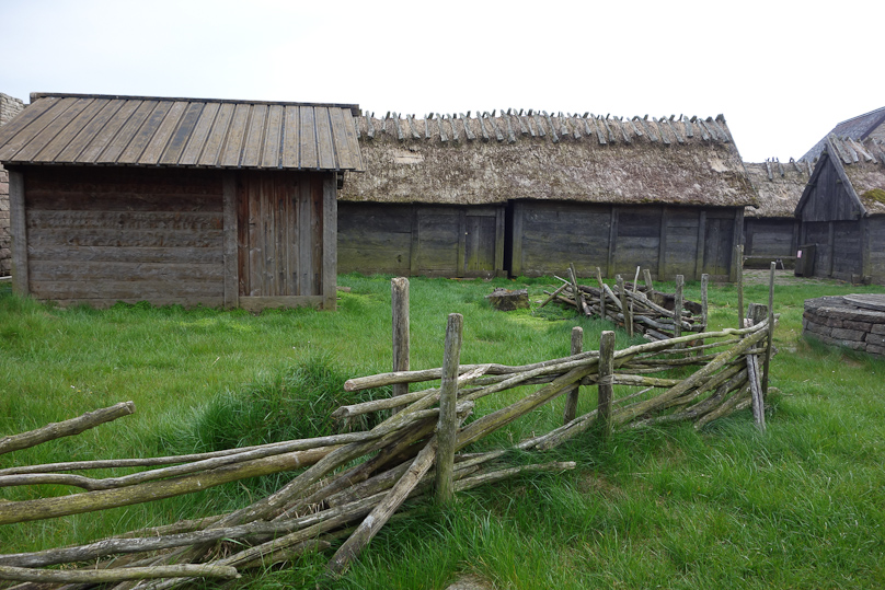 The battens crisscrossing on the roof ridge hold the thatching in place.