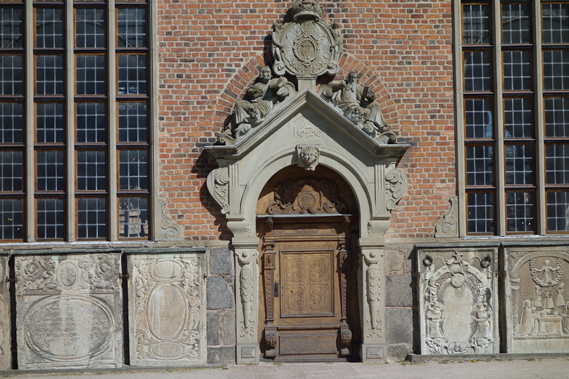 The north door is elaborately decorated and flanked by memorials from the floor of the church that were moved when all the bodies interred there began to smell so bad that they were all removed in the 19c.