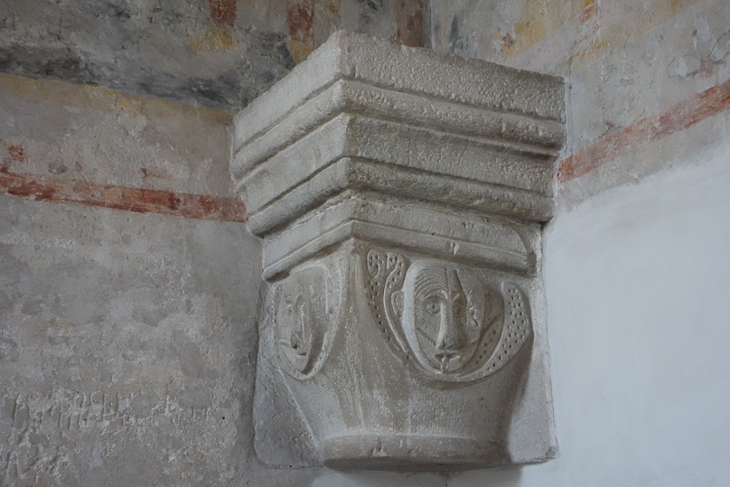 A capital in Mariakyrkan in Vä with two curious, crude faces.