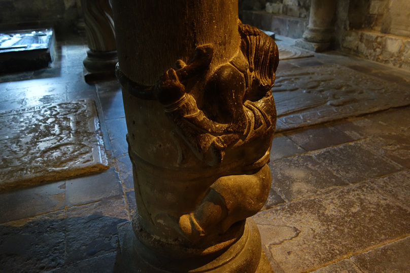 The squatty little person has a rope in his left land that goes around the back of the column.