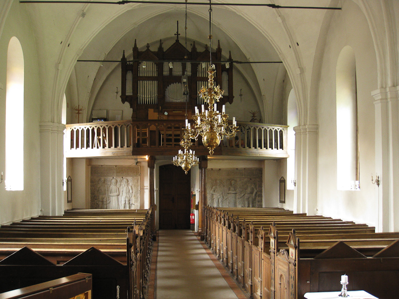 The nave of the church has reverberating spaces in the wall behind the organ.