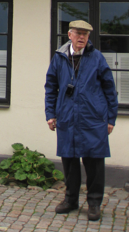 I in my tourist uniform: blue raincoat, boots, camera, and cap.