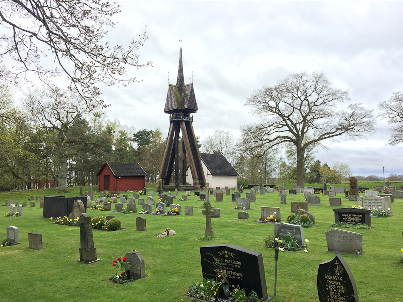 The bell tower and cemetery are south of the church at Hagby.